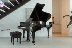 a grand piano in a living room next to a stair case